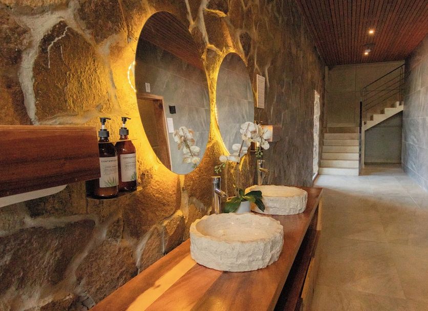 Contemplacion Resort & Spa in Ensenada spa room with stone walls, mirrors and a wooden bench