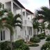 Volga Apartment Hotel in Mũi Né with white balconies, palm trees, and a landscaped walkway