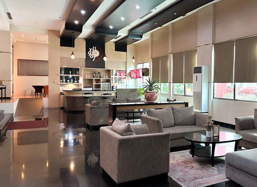 Grand Daira Hotel Palembang lounge with sofas, round table, and large windows in Palembang