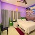 Anukampa Paying Guest House in Agra room with bed, curtains, chair and scenic wall mural