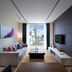 Shama Sukhumvit Bangkok living room with sofa, wall TV, and city skyline view in Bangkok