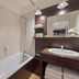Appart'City Classic Genève - Gaillard bathroom with bathtub, sink vanity, mirror and shower head