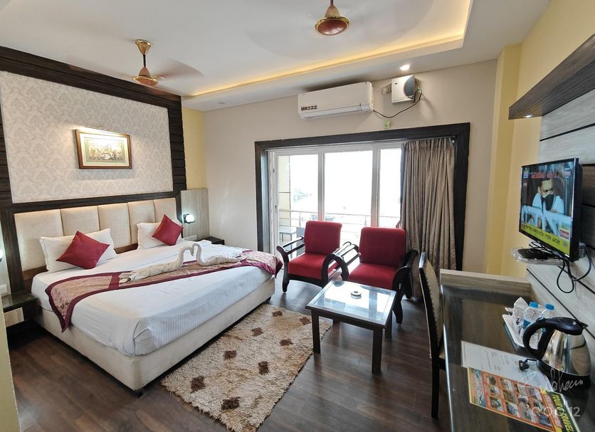 Hotel Sagar Kanya Inn, Puri: guest room with double bed, seating area, TV, and balcony doors