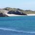 Doonmore Hotel in Inishbofin with a scenic view of turquoise sea, sandy beach and rocky hills