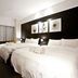 Stay Inn Taipei City guest room with two beds, dark accent wall, and curtains