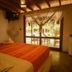 La Casa de Sebas in Máncora bedroom with bed, hammock, and patio doors to tropical garden