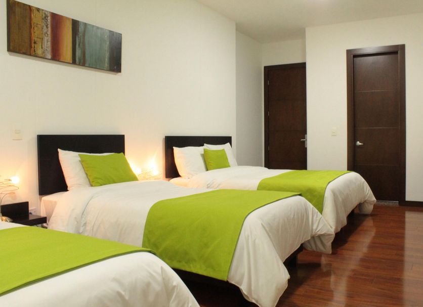 Hotel macao colombia Bogotá guest room with three twin beds and wood flooring