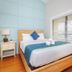 Surf House in Hampton guest room with queen bed, blue accents, and window blinds
