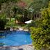 Ka'ana Resort in San Ignacio with a blue outdoor pool surrounded by lush tropical gardens and lounge chairs