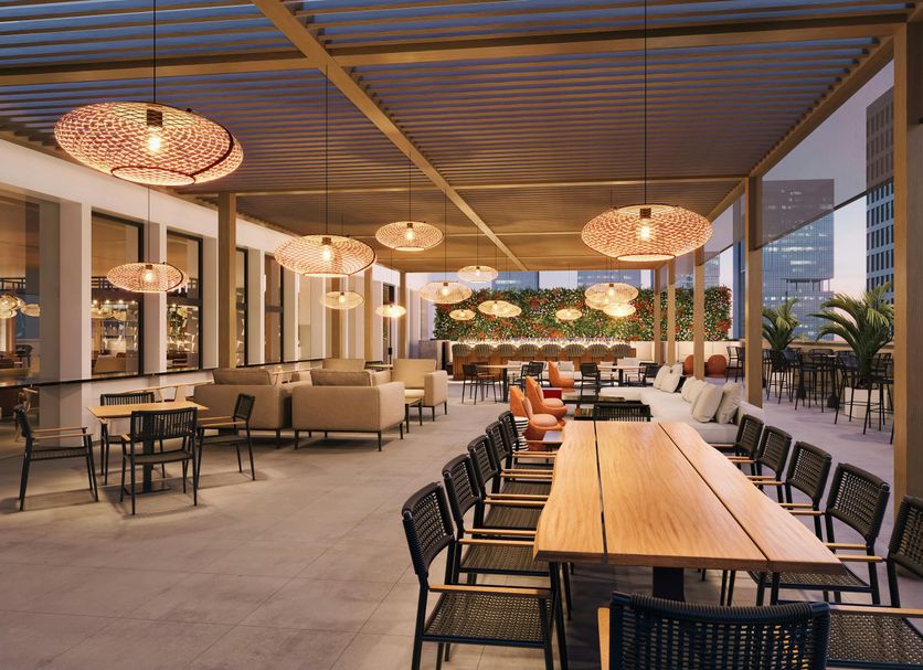 Hilton Motif Seattle rooftop terrace with long dining table and city skyline views