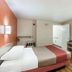 Motel 6 Newport News, VA room with bed, desk, wall-mounted TV, and wood flooring