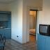 Resort Itaca - Nausicaa room with kitchenette, table flowers and TV in Rossano