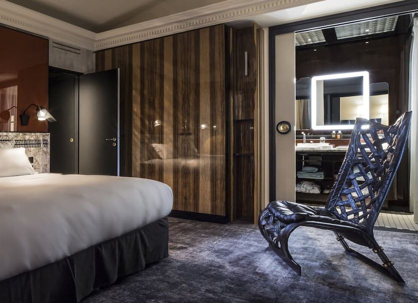 Hotel Les Bains Paris room with canopy bed and sculptural lounge chair in Paris