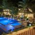 Le Pearl Goa Resort & Spa in Vagator: illuminated outdoor pool with loungers and tropical greenery