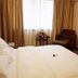 Nan Xiang Hotel - Guiyang guest room with bed, window, armchair, TV and cabinet