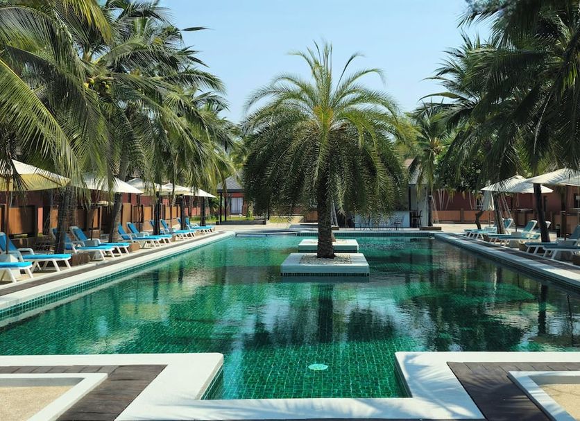 Baan Mesuk Hua Hin Spa and Resort pool with palm trees and lounge chairs in Hua Hin