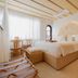 Donatella Boutique Hotel Miami Beach guest room with king bed, wicker bench, desk and arched window
