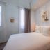 Makom Pereire Paris guest room with double bed, bedside lamps, window and wall art