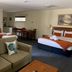Armidale Pines Motel in Armidale room with sofa, beds, dining table and kitchenette
