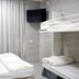 Hi Rabin - Jerusalem Hostel room with bunk beds, wall-mounted TV, and curtained window in Jerusalem