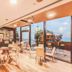 Nof Hotel Haifa lounge with tables, wall art, and floor-to-ceiling windows overlooking the sea