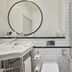 Titanic Hotel Belfast bathroom with tiled shower, bathtub, sink, and round mirror in Belfast