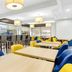 Comfort Inn Greenville - Haywood Mall breakfast area with tables, bar seating and yellow and blue chairs