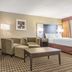 Quality Inn & Suites Windsor room with sitting area, king bed and bathroom