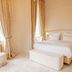 Château De Noirieux room in Briollay with a king bed, large windows, and cream curtains