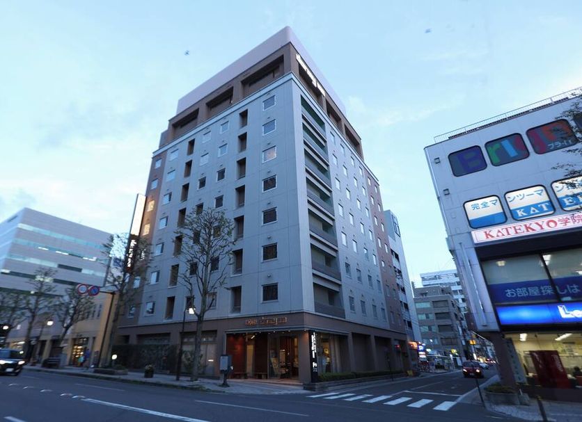 Dormy Inn Matsumoto in Matsumoto, exterior of a tall modern hotel at a street intersection