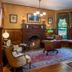 1899 Wright Inn & Carriage House in Asheville: ornate parlor with fireplace, bay window seat, and antique clock