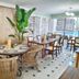 allsun Hotel Paguera Vera Beach in Peguera dining room with wicker chairs, tables, and large windows