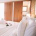 Pousada Encantada in Trancoso bedroom with king bed, TV, and wooden wardrobe