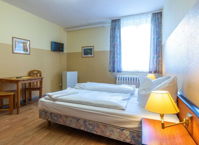 Pension Schwalbenweg in Schönefeld guest room with twin beds, desk, TV, and bright window