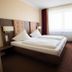 Europa Kehl Hotel guest room in Kehl with twin beds, large window, and desk