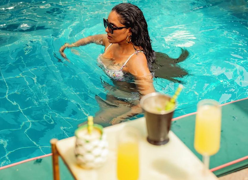 Townhouse Boutique Hotel in Cartagena with a woman swimming in a turquoise pool beside drinks