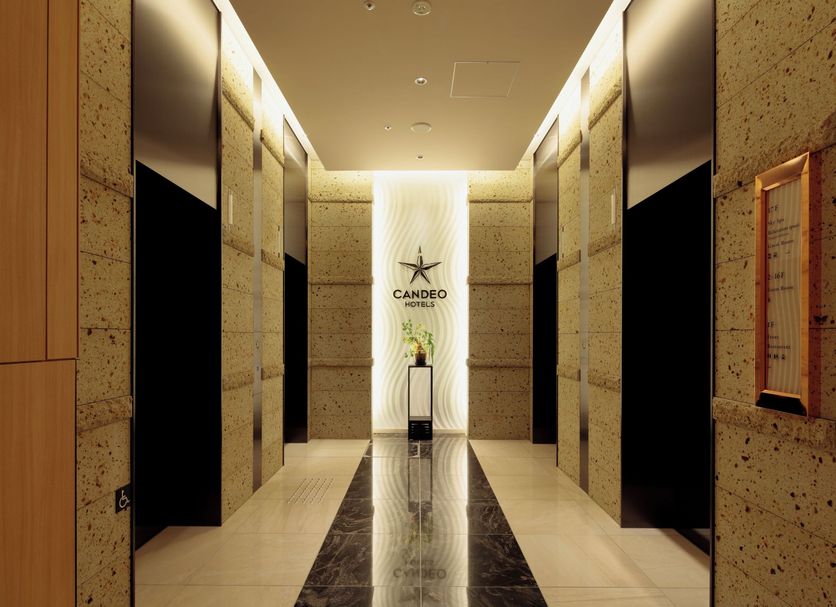 Candeo Hotels Osaka Namba lobby hallway with stone walls, mirrored panels, and central decorative screen