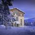 Lapland Hotels Riekonlinna in Saariselka, snowy hotel exterior with winter trees at dusk