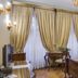 Villa Fenaroli Palace Hotel in Brescia guest room with ornate curtains, desk, TV and chandelier