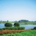Fletcher Hotel Restaurant De Gelderse Poort in Ooij with a tranquil lakeside wetland and greenery