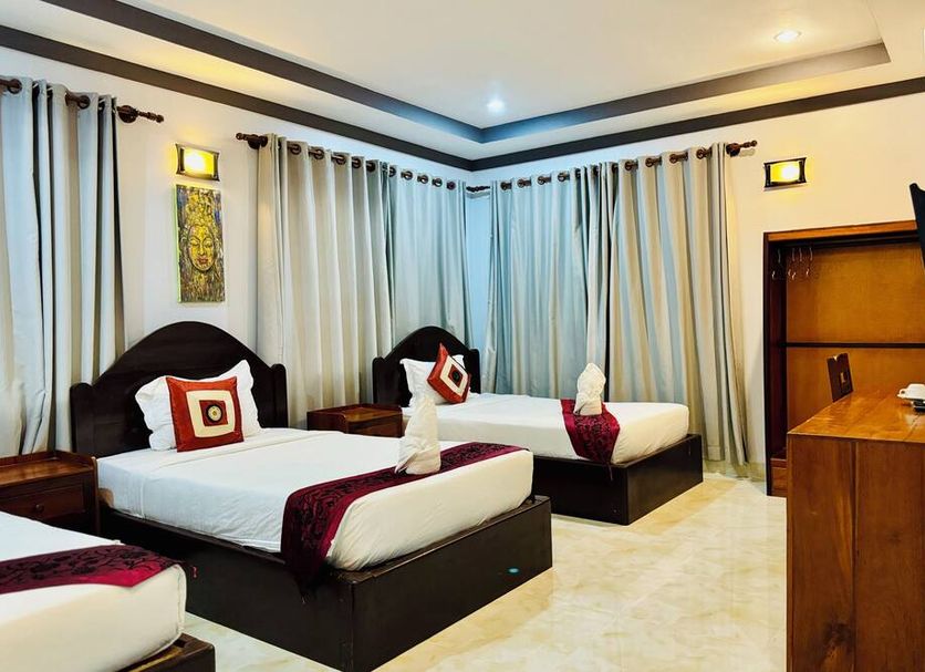 Golden Bakong Boutique Siem Reap guest room with three single beds and curtained windows