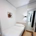 Pensión Régil, San Sebastian: compact single room with white bed, wall art, and mirrored wardrobe