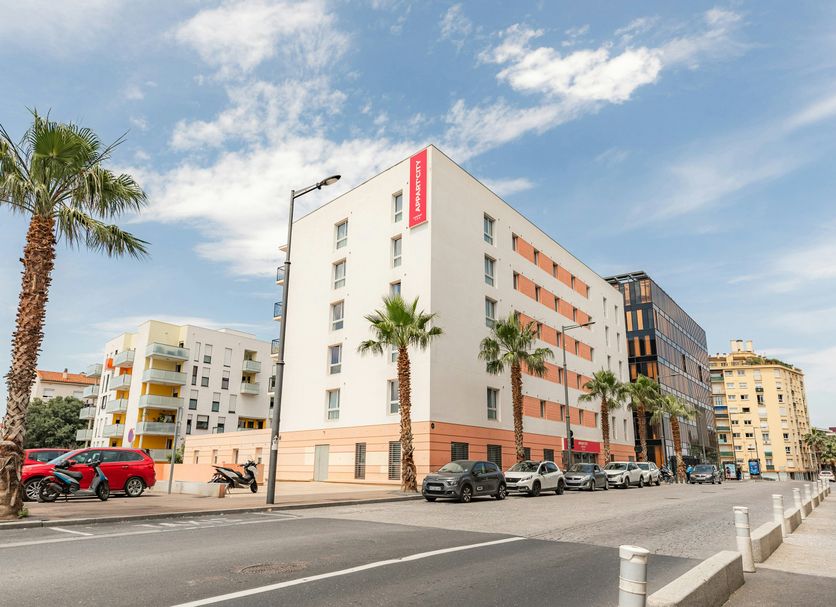 Appart'City Confort Perpignan Centre Gare exterior on a city street in Perpignan with palm trees