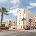 Appart'City Confort Perpignan Centre Gare exterior on a city street in Perpignan with palm trees