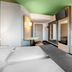 B&B Hotel Baden-Airpark room in Rheinmunster with twin beds, desk, wall TV and green ceiling