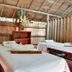 El Refugio Hotel & Spa in Sasaima spa treatment room with two massage tables and wooden walls