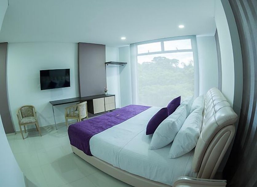 Solev Hotel Villavicencio room with king bed, purple accents and large window view