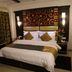 Sri Nanak Continental Hotel, New Delhi guest room with king bed, patterned headboard, and bedside lamps