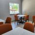 Baymont by Wyndham San Antonio Airport meeting room with tables, orange chairs, and a window in San Antonio
