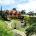 Sunny Point Hotel in Davao City with garden, driveway, and two-story building under a red roof
